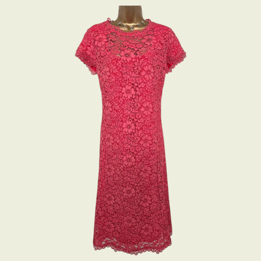 Mannequin wearing cerise lace dress on beige background