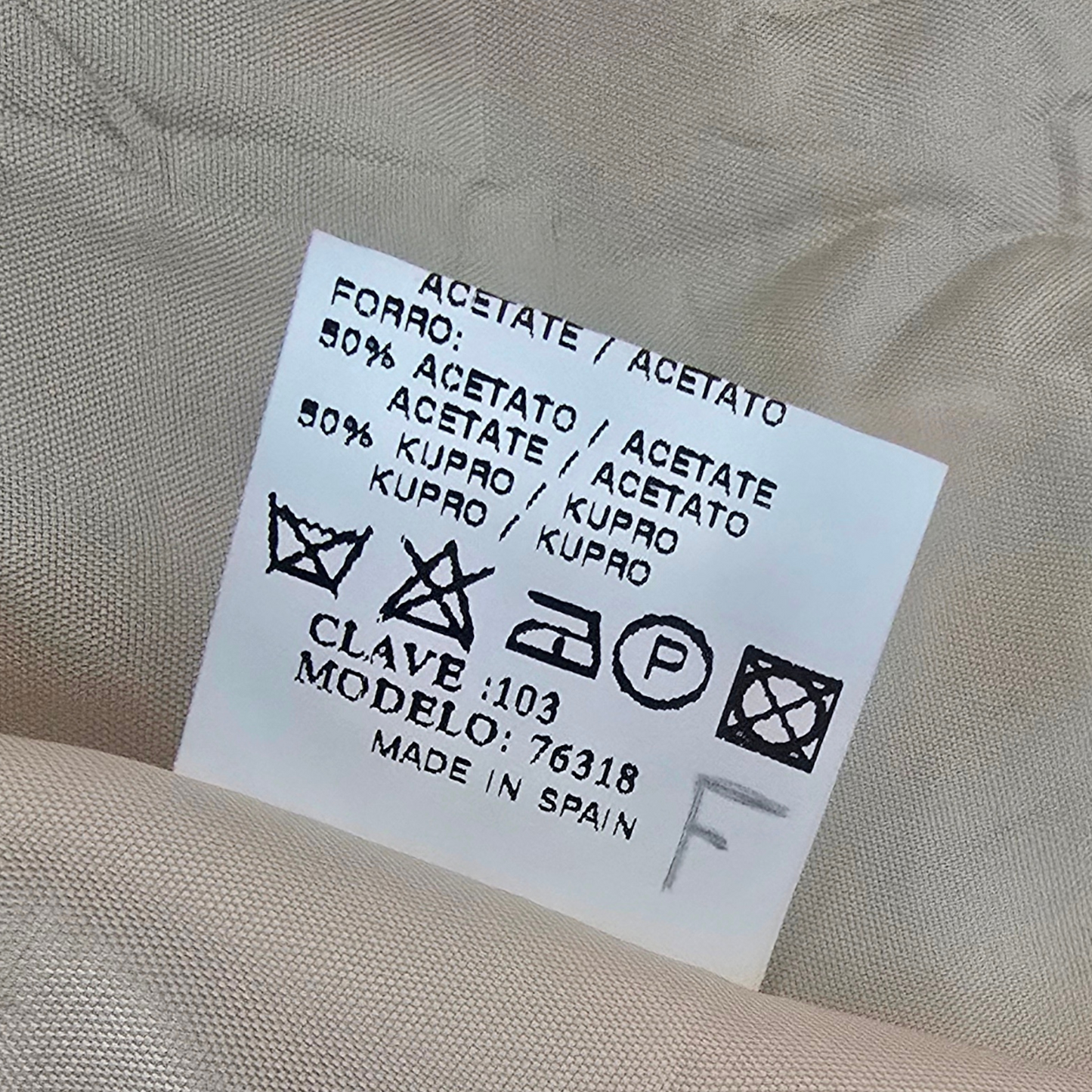 Clothing label with washing instructions on a beige background