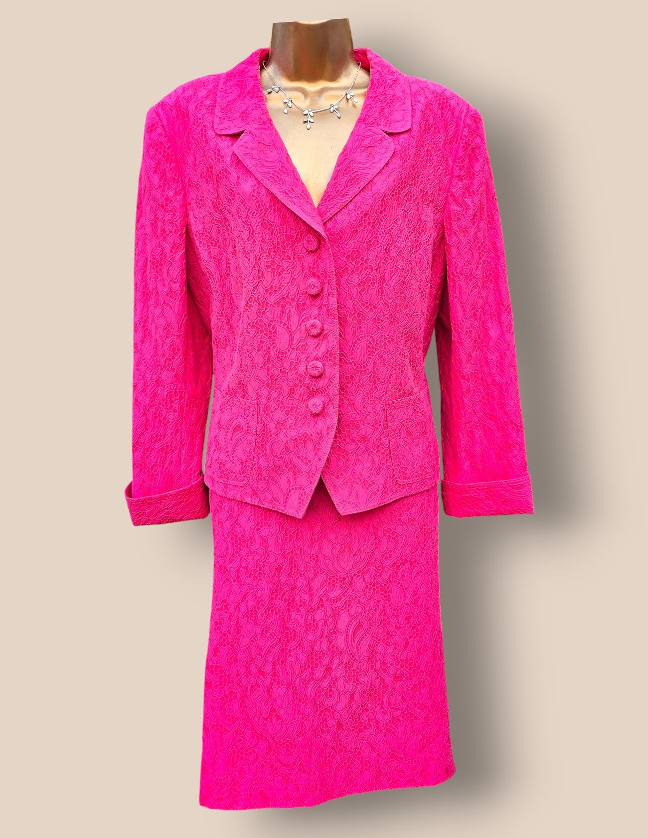 Pink suit on a mannequin against a beige background