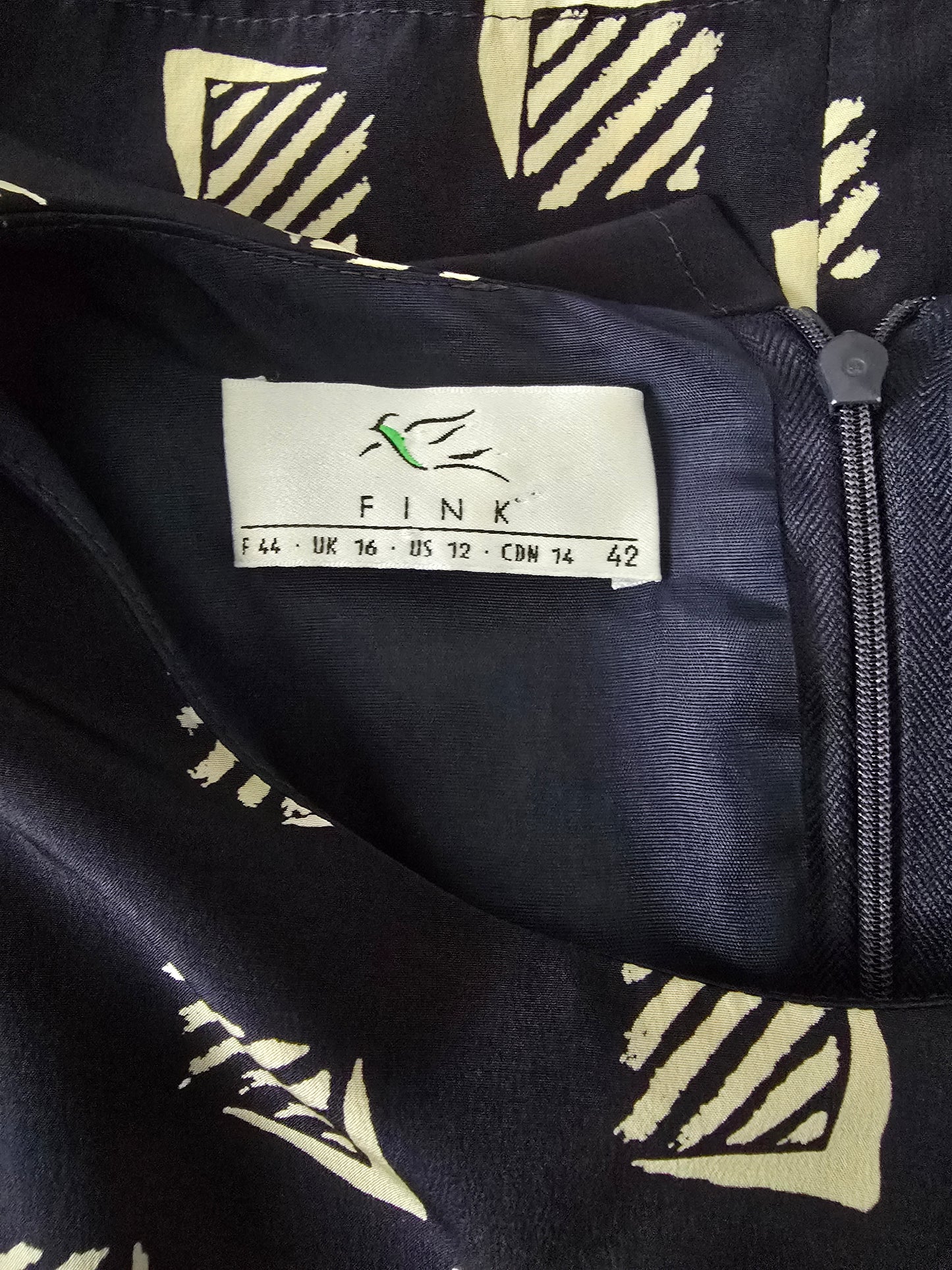 Navy blue bag with beige geometric patterns and a visible brand label on a matching background.
