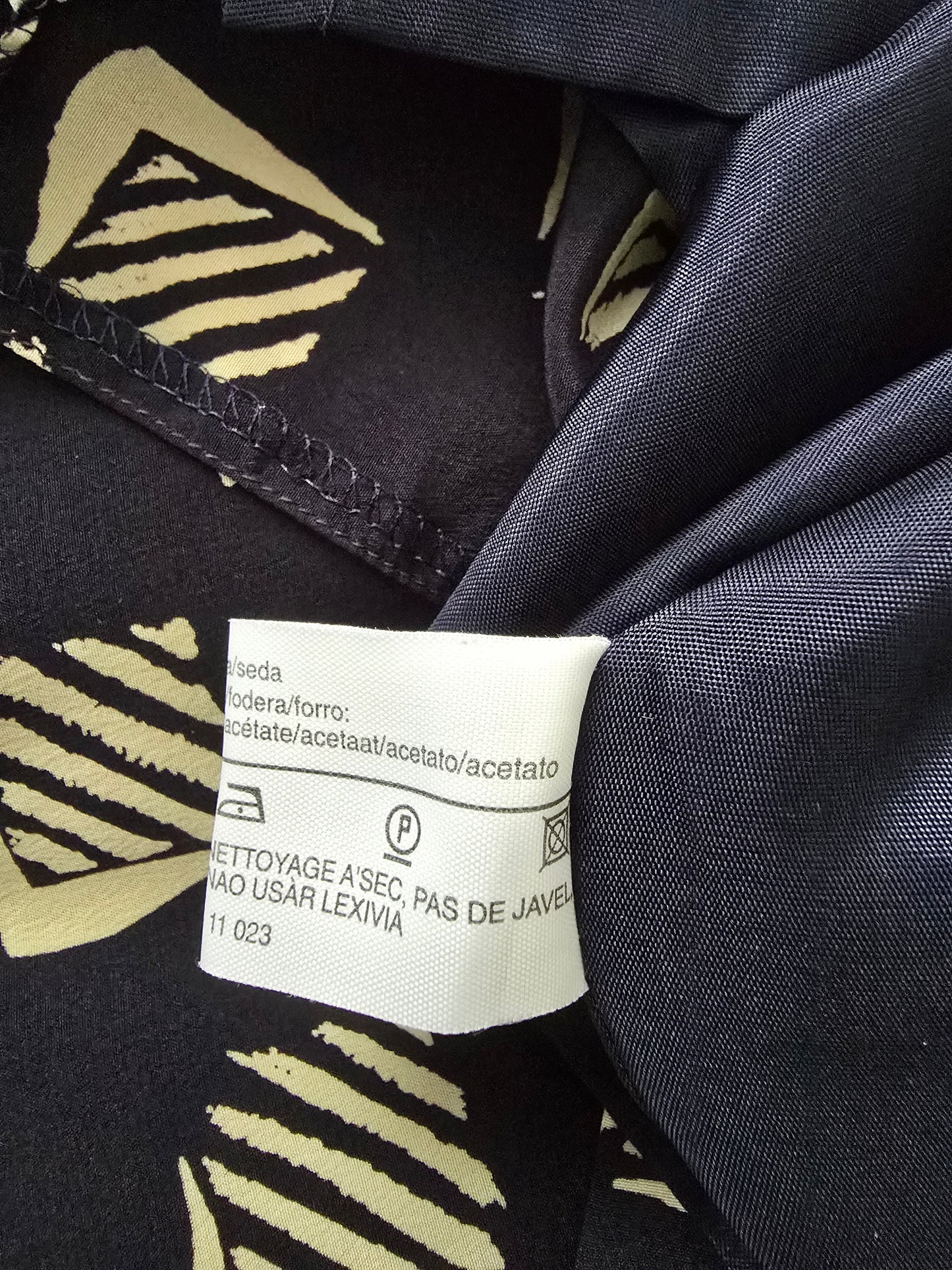 Clothing label on a dark fabric with a pattern