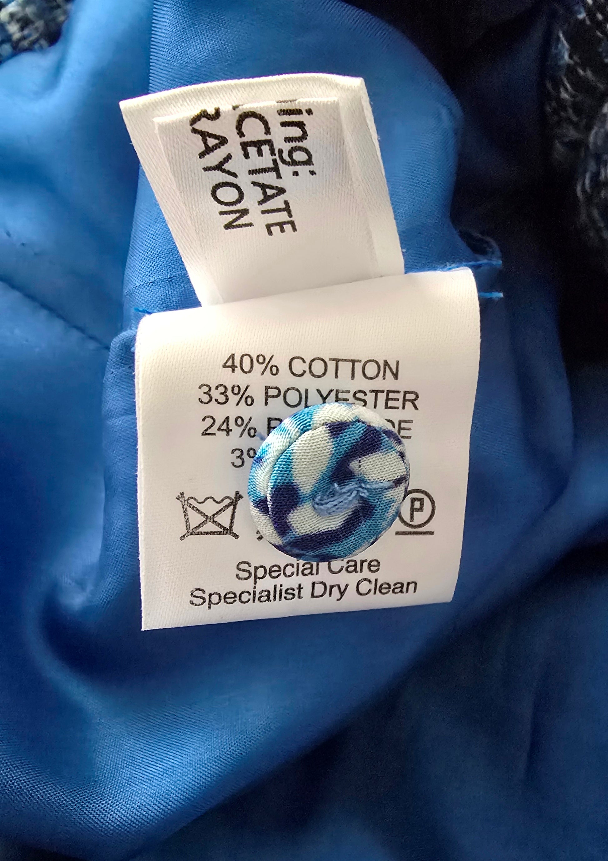 Clothing label with fabric composition and care instructions on a blue fabric background