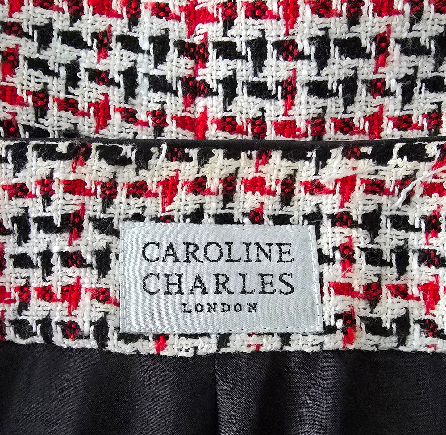 Close-up of a patterned fabric with a 'Caroline Charles London' label.