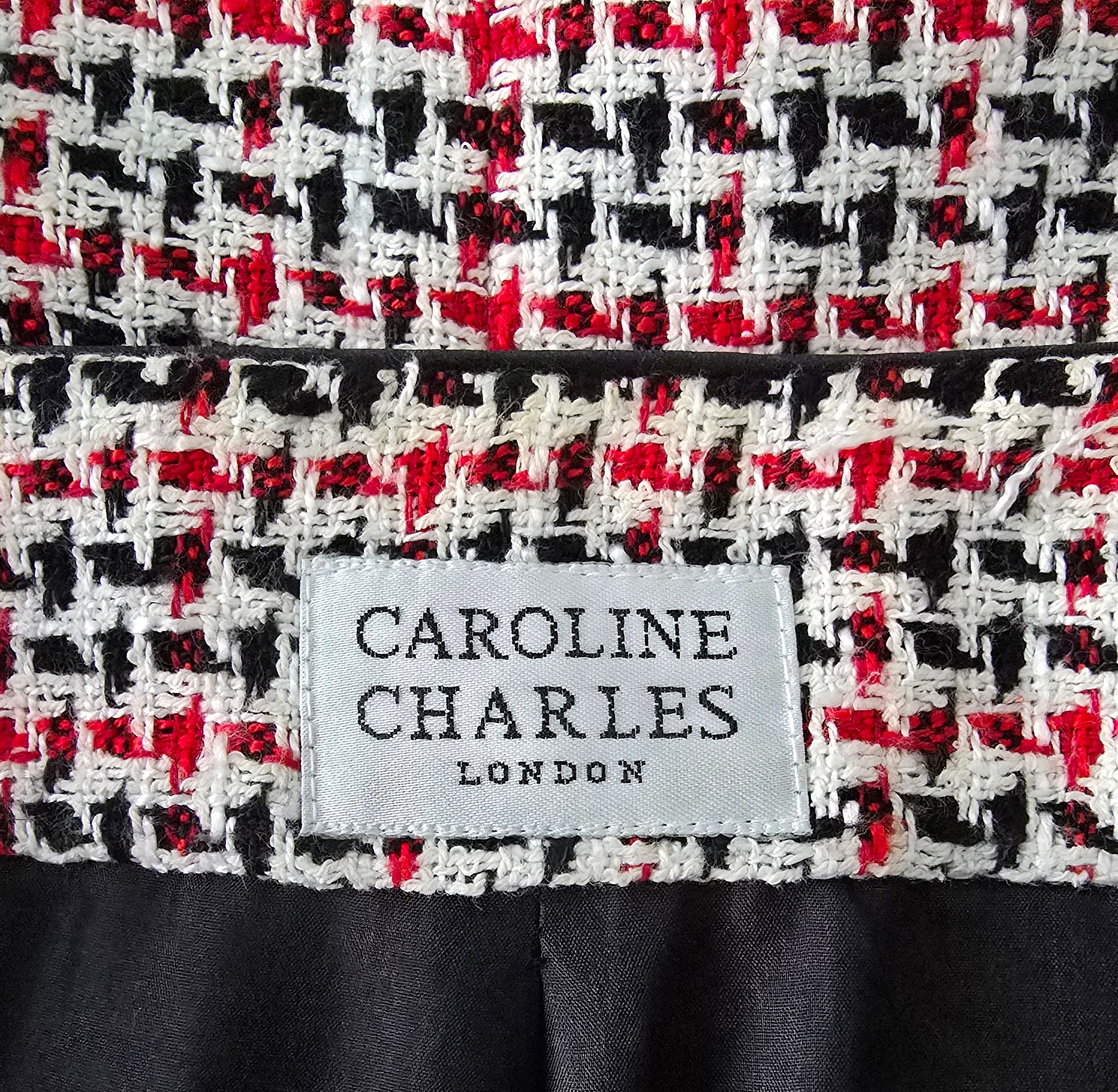 Close-up of a patterned fabric with a 'Caroline Charles London' label.