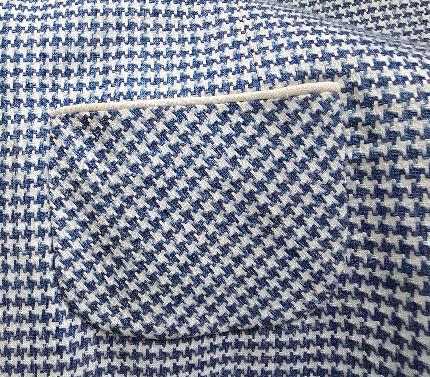 Close-up of blue and white houndstooth pattern fabric with a needle.