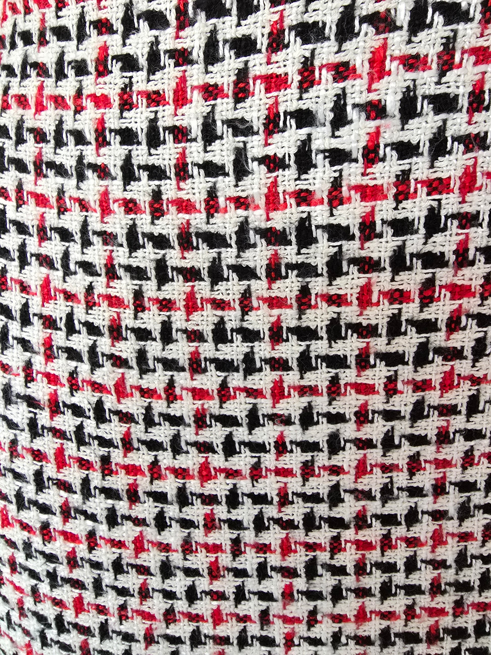 Close-up of a fabric with a houndstooth pattern in black, red, and white.