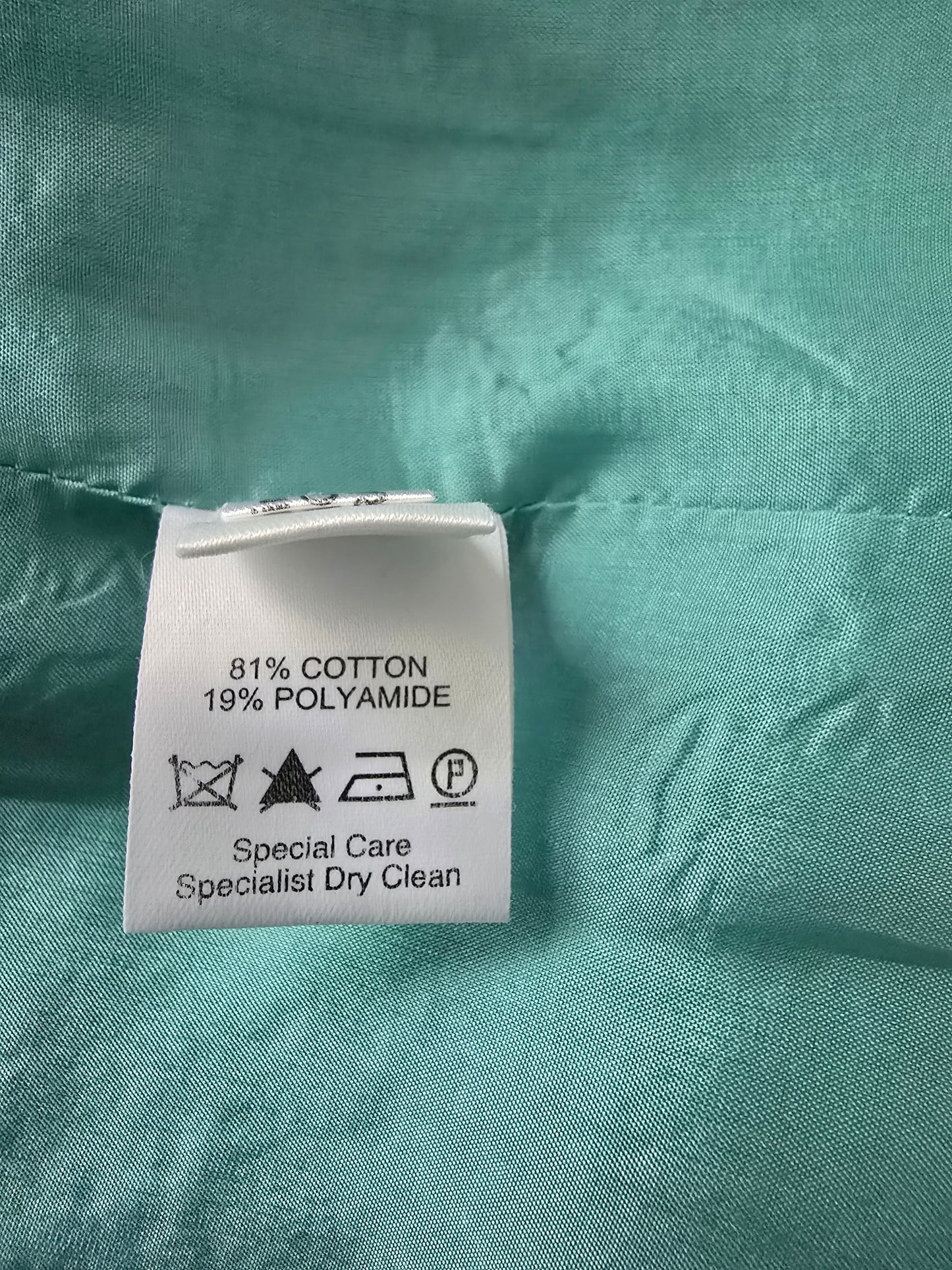 Clothing label on a turquoise fabric background