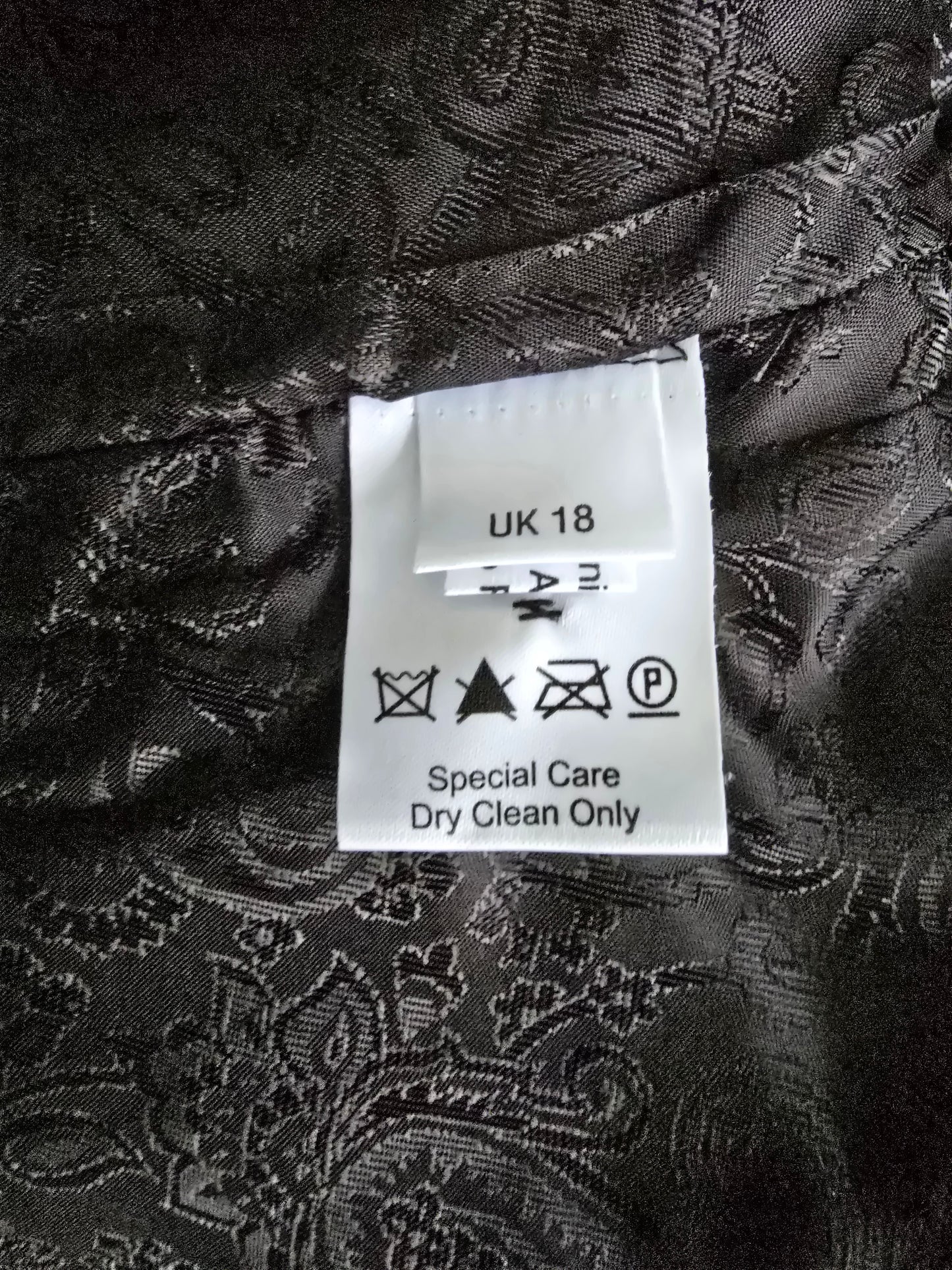 Clothing label on a black patterned fabric