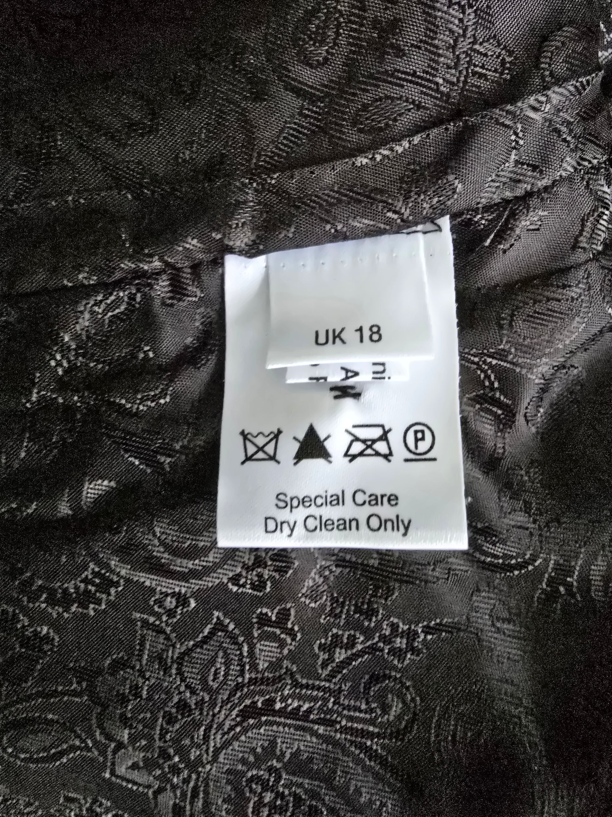 Clothing label on a black patterned fabric