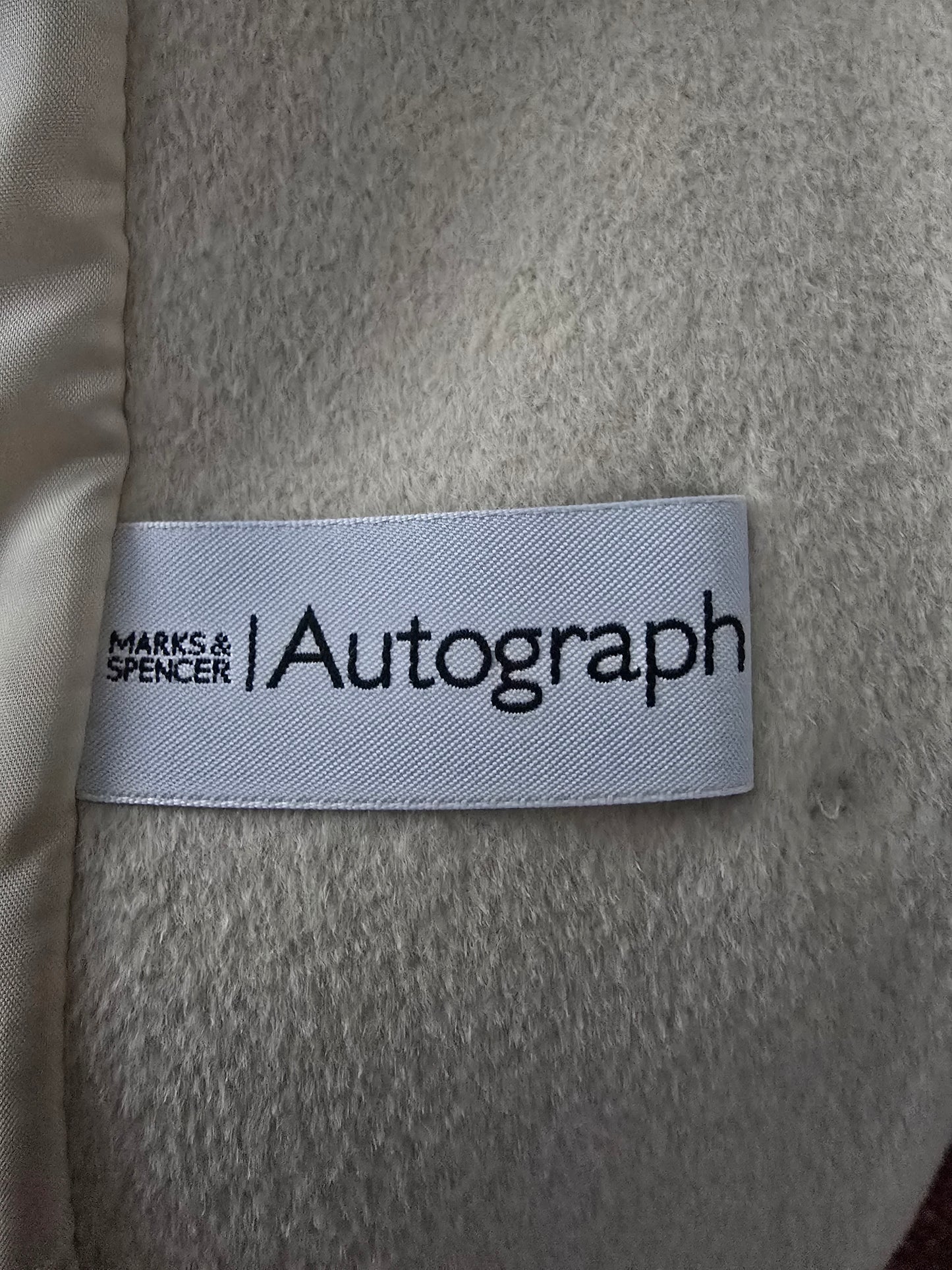 Label with 'Autograph' text on a textured fabric background