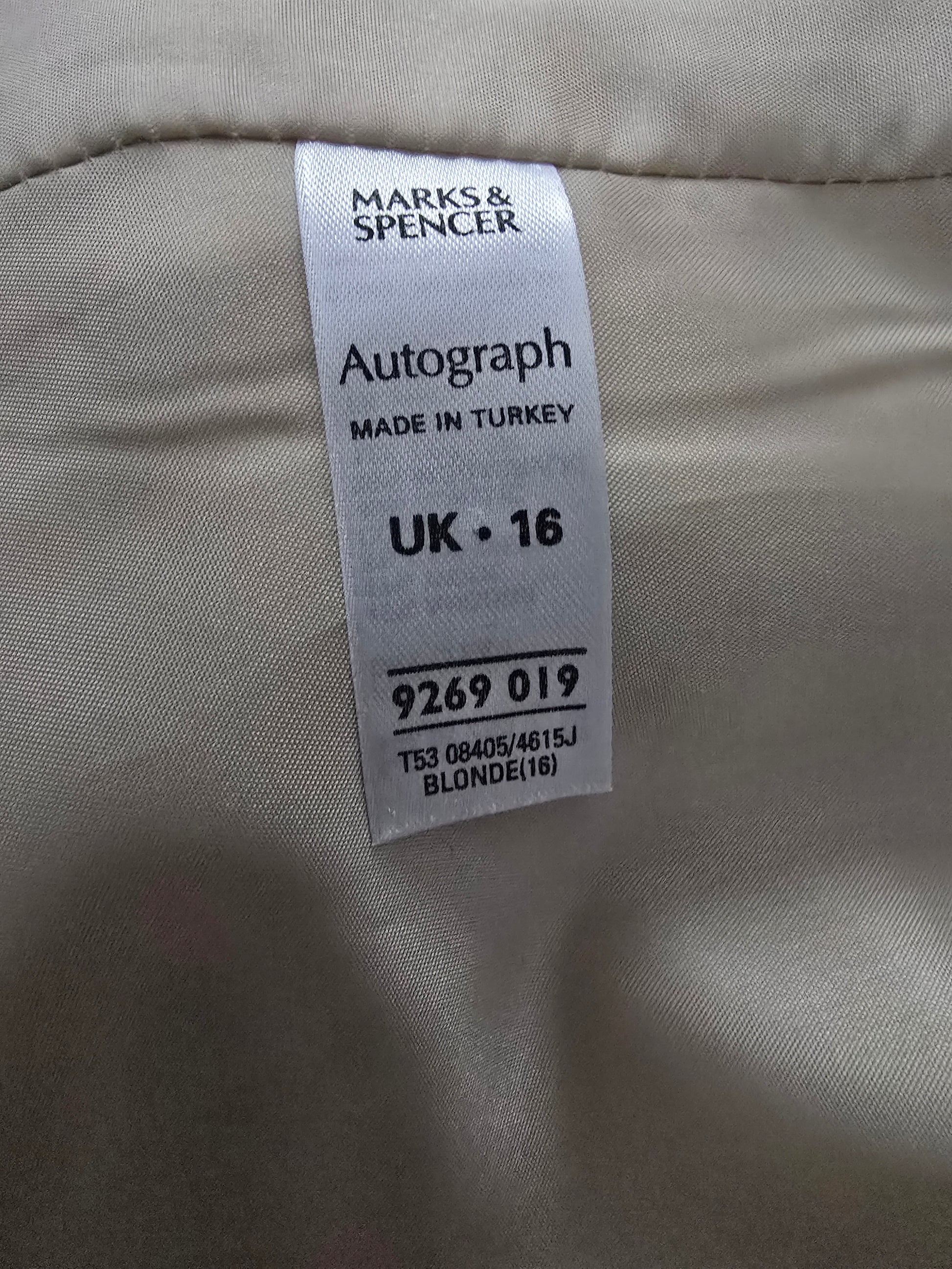 Clothing label on a beige fabric background with 'Marks & Spencer' branding.