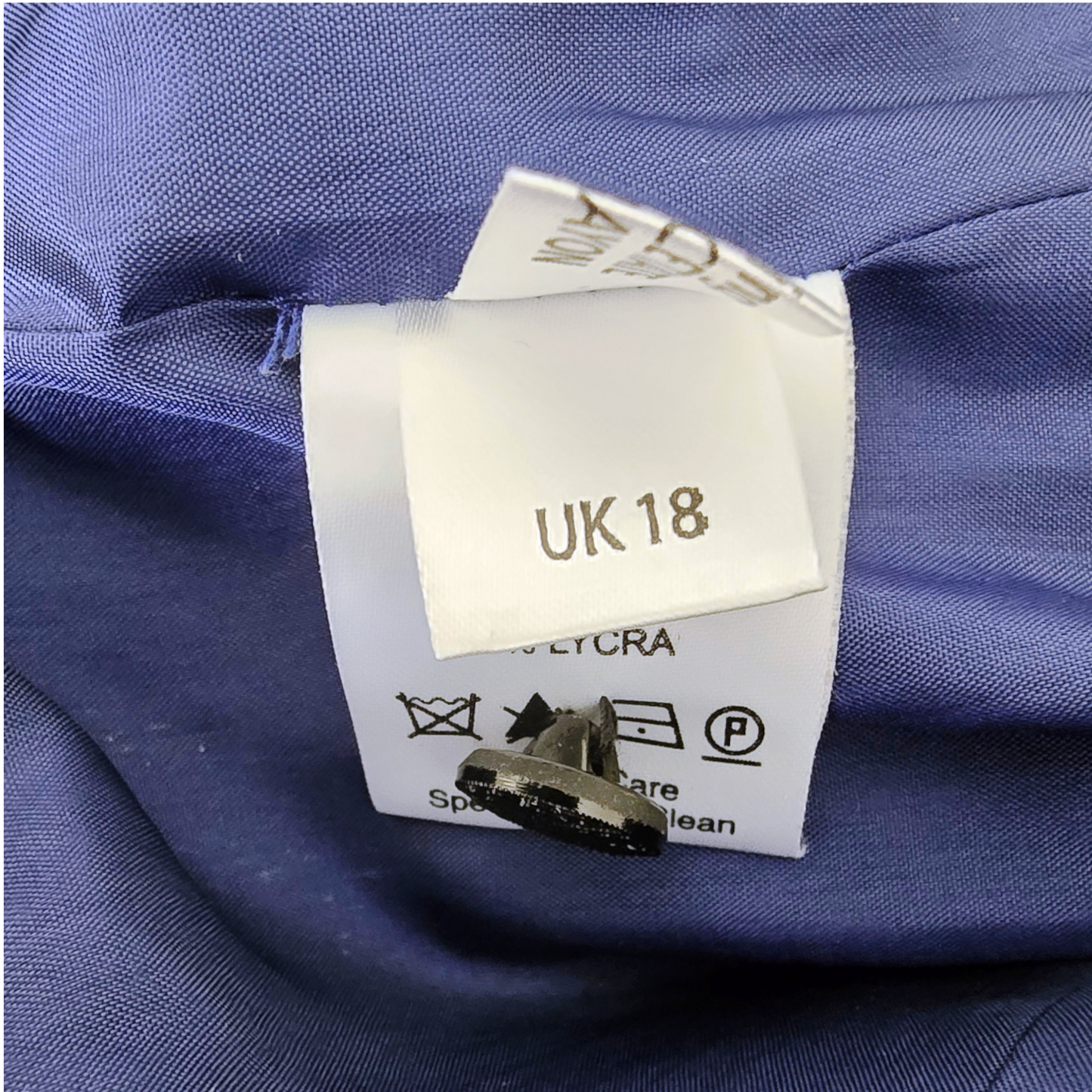 Clothing label with size 'UK 18' on a blue fabric background