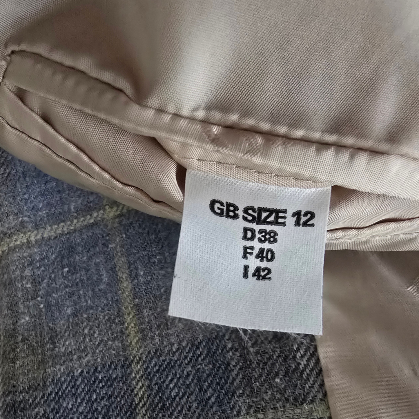 Size label on a piece of clothing with text 'GB SIZE 12 D38 F40 I42'.