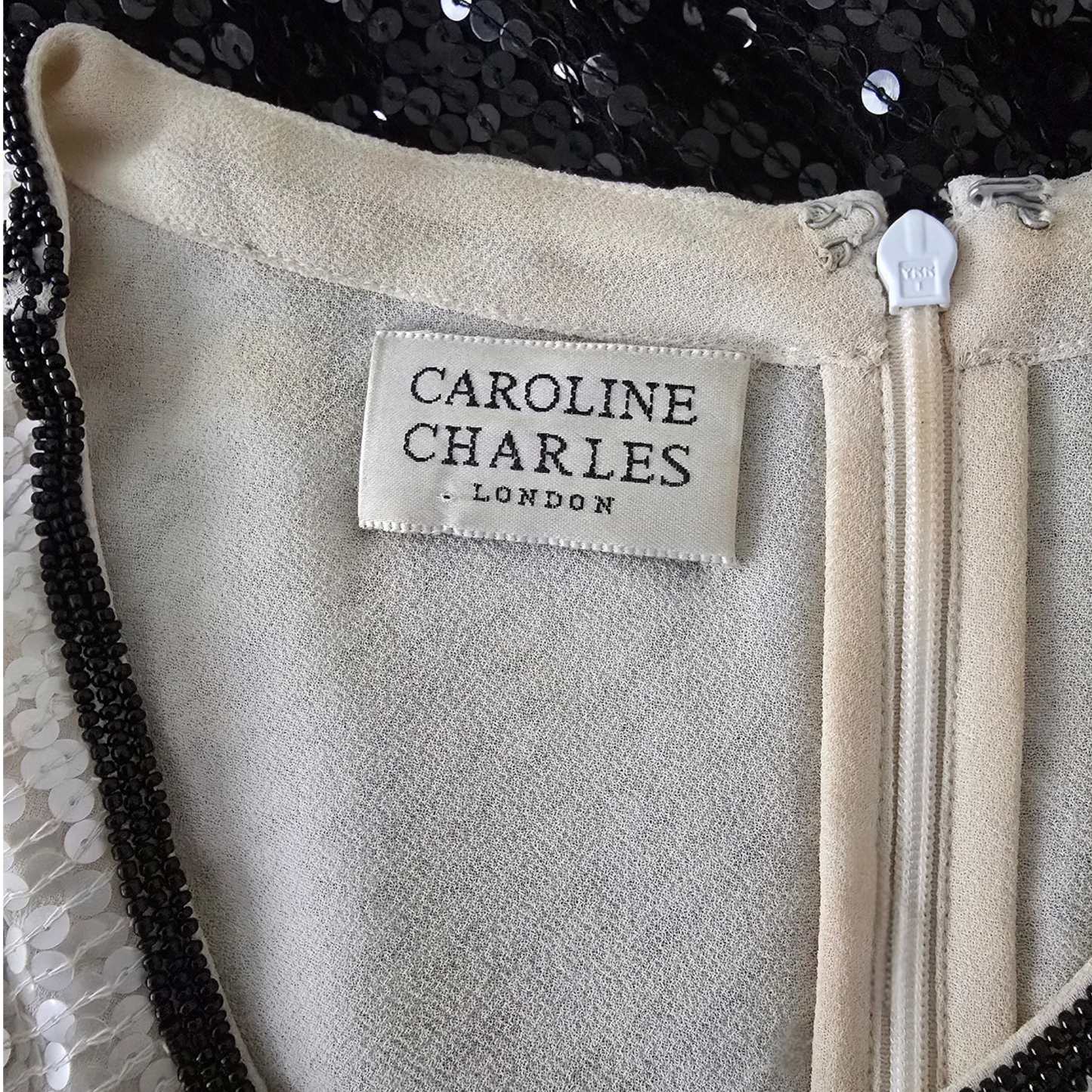 Close-up of a label on a garment with 'Caroline Charles London' branding.