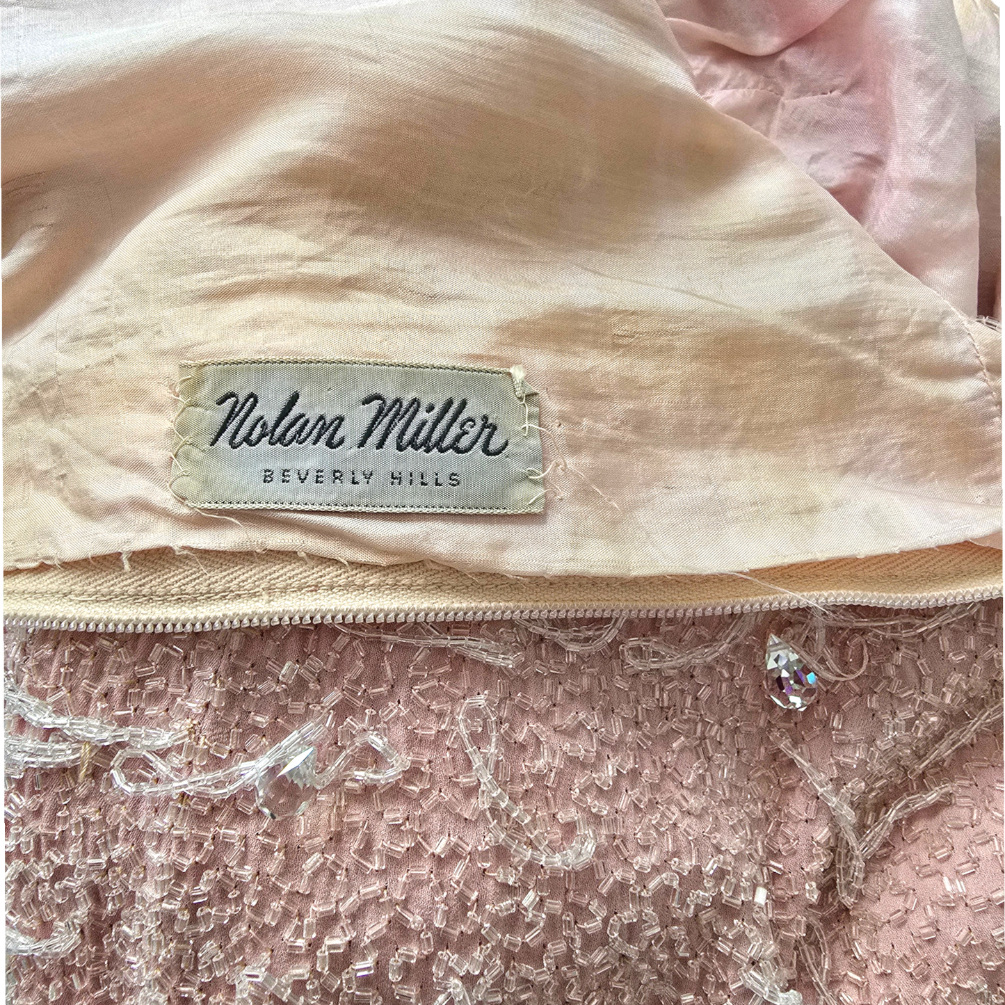 Nolan Miller Beverly Hills label on peach background