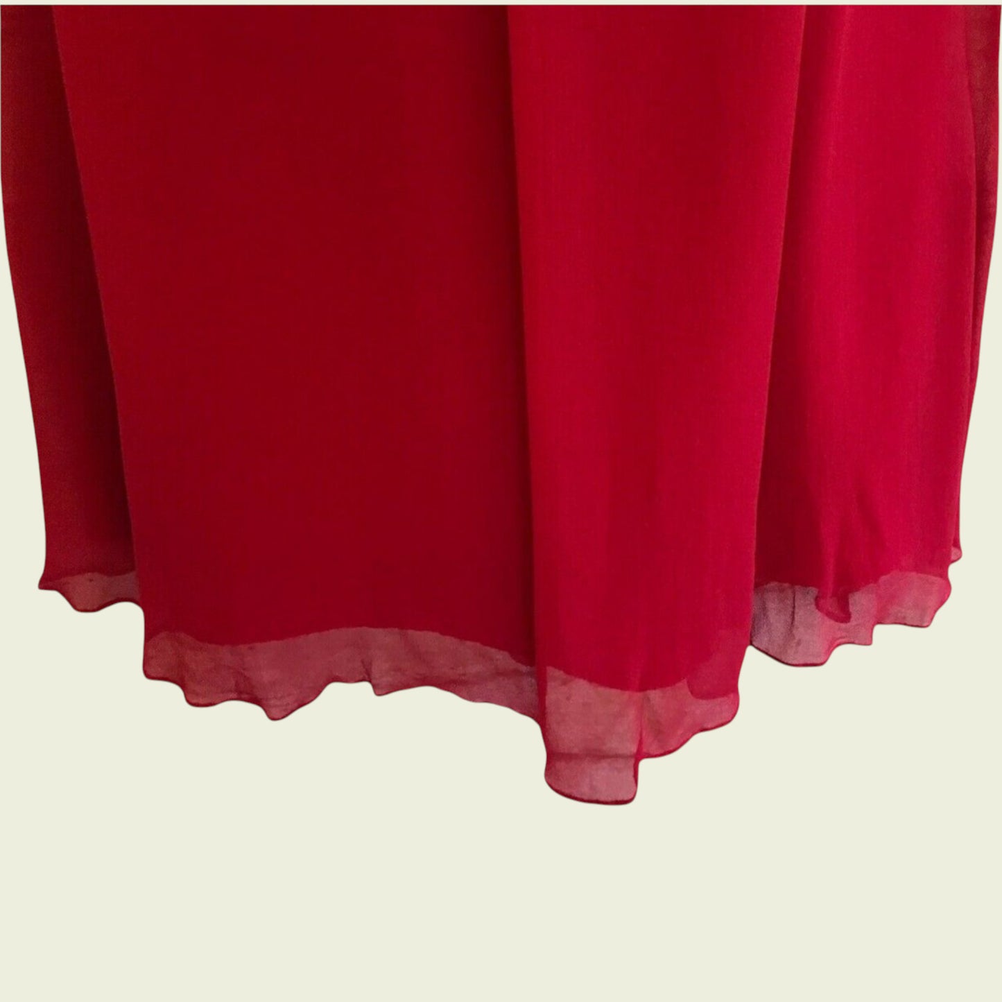 Red fabric with a textured edge on a beige background