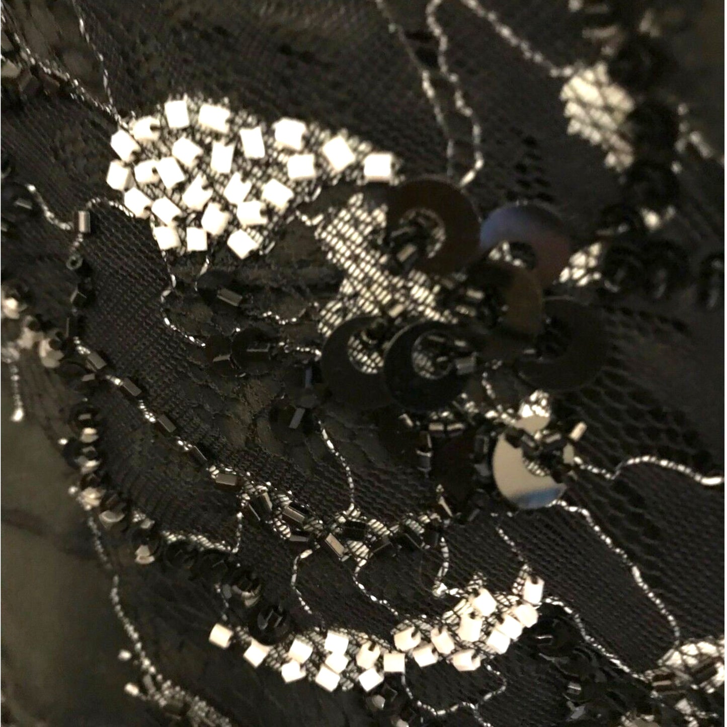 Close-up of black lace fabric with silver embellishments