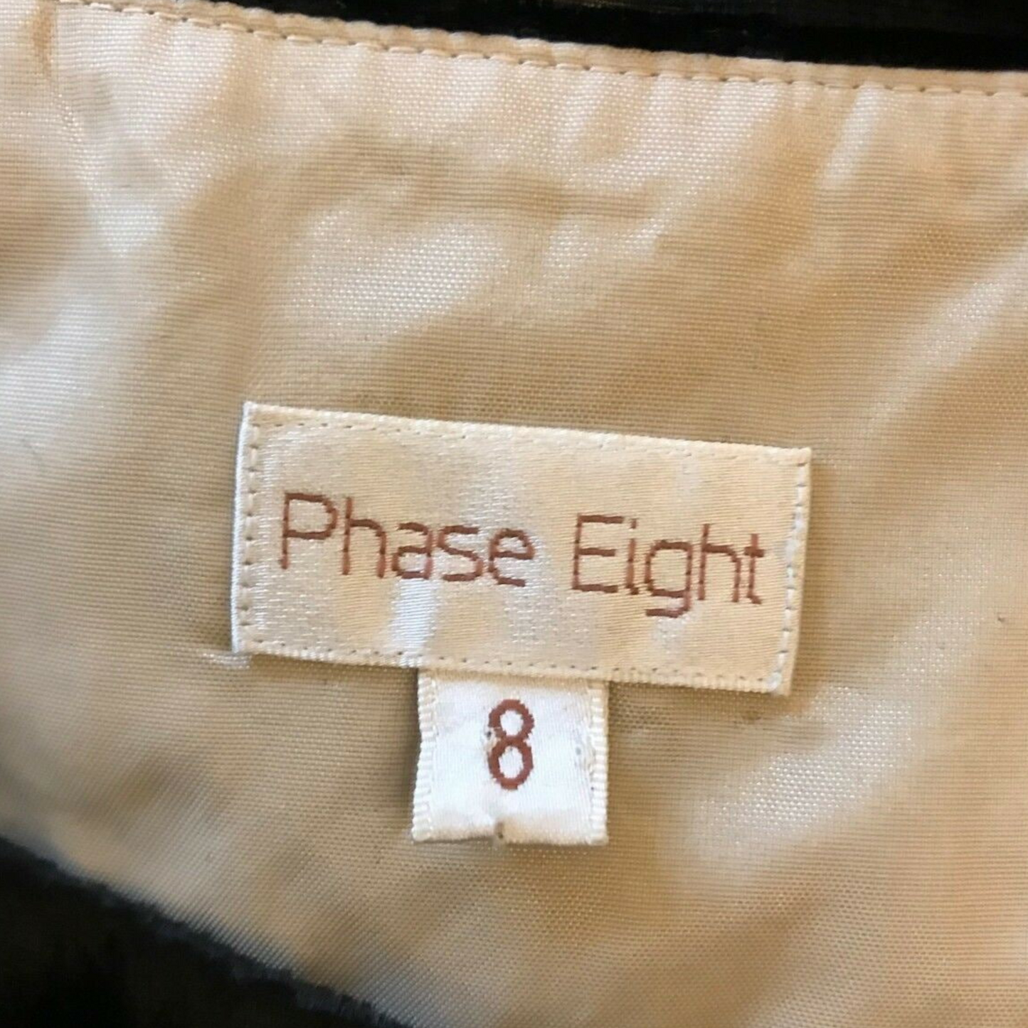 Phase Eight label on a beige fabric background