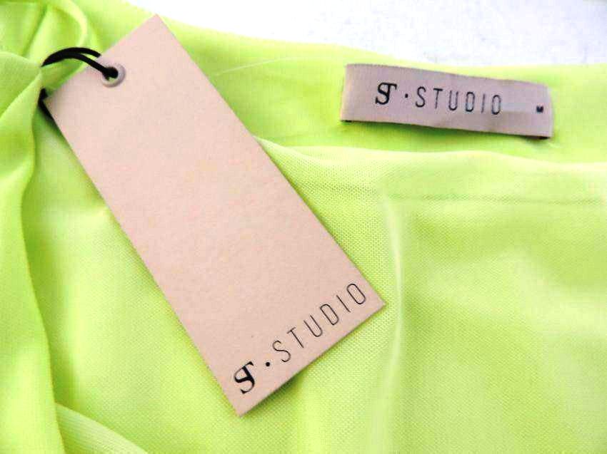 Green fabric with 'S Studio' tags on a white background