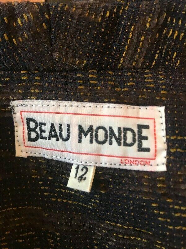 Label with 'BEAU MONDE' text on a textured fabric background