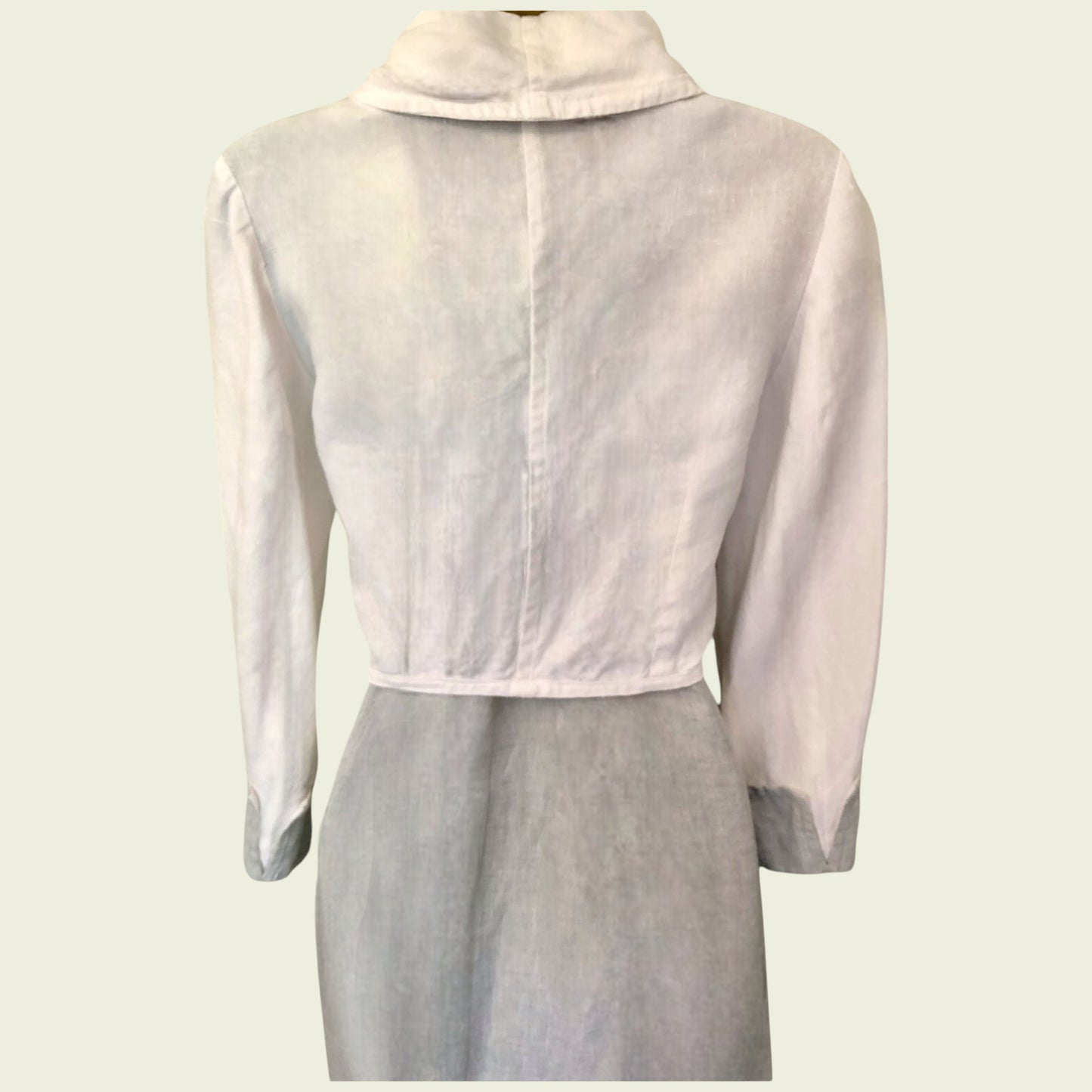 Light pink sheer jacket over a light gray dress on a white background