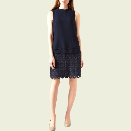 Navy sleeveless dress with lace detail on a beige background