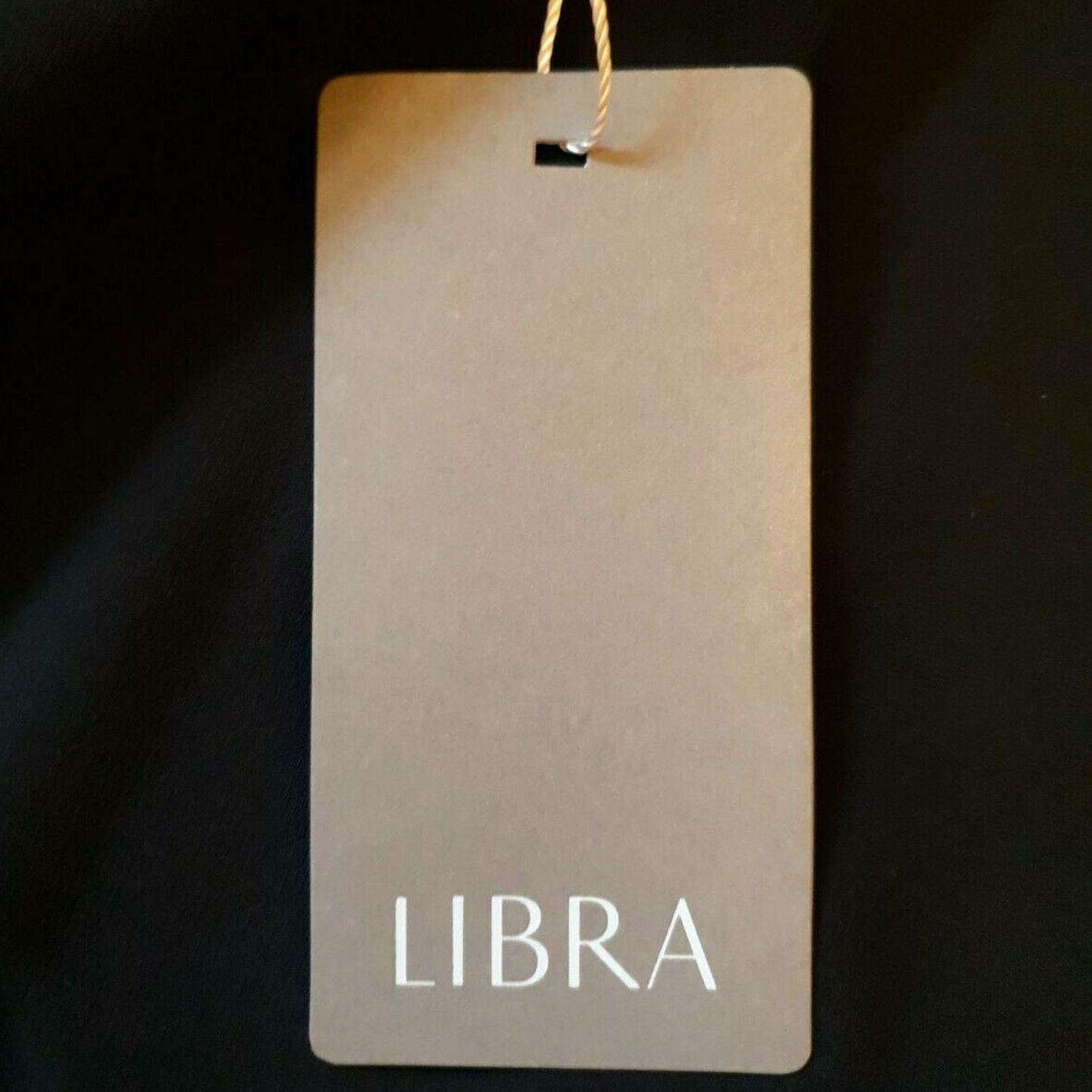 Clothing tag with 'LIBRA' text on a dark background