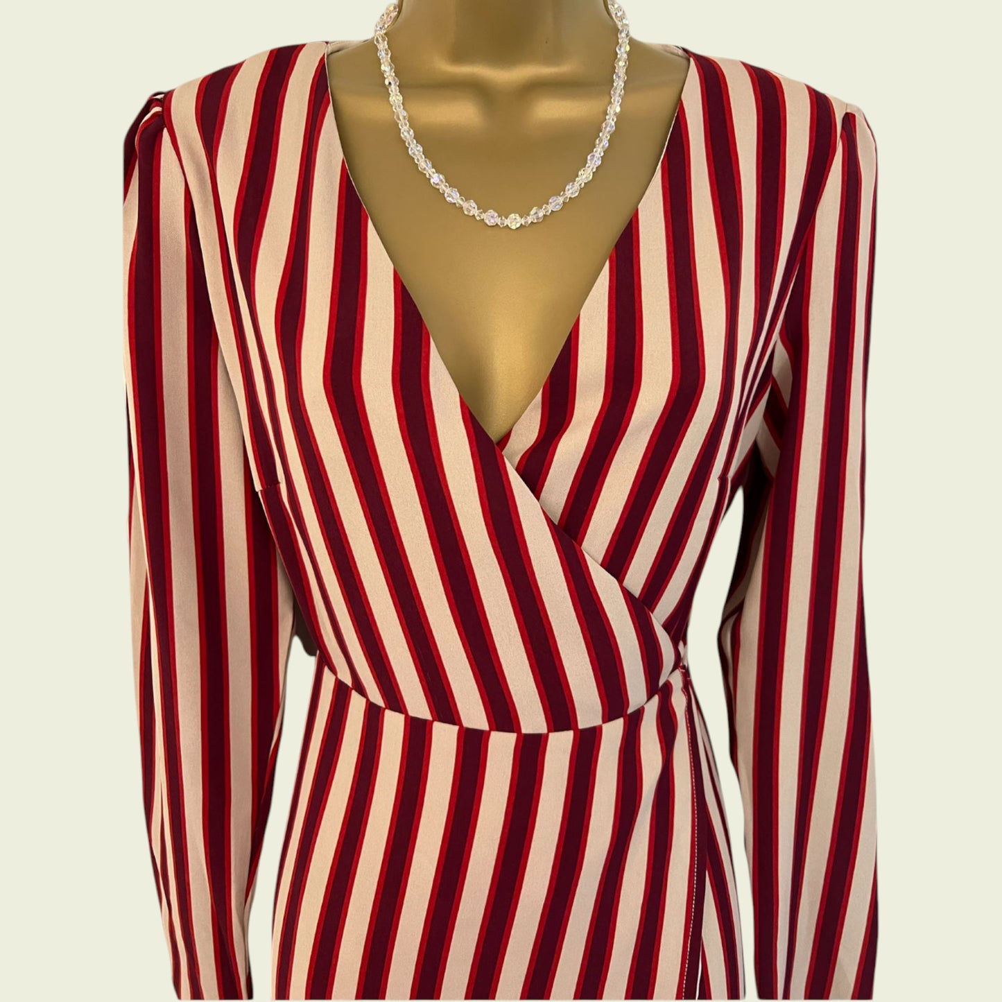 Red and beige striped dress on a mannequin with a plain background