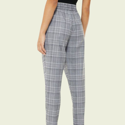 Plaid pants worn by a person on a beige background
