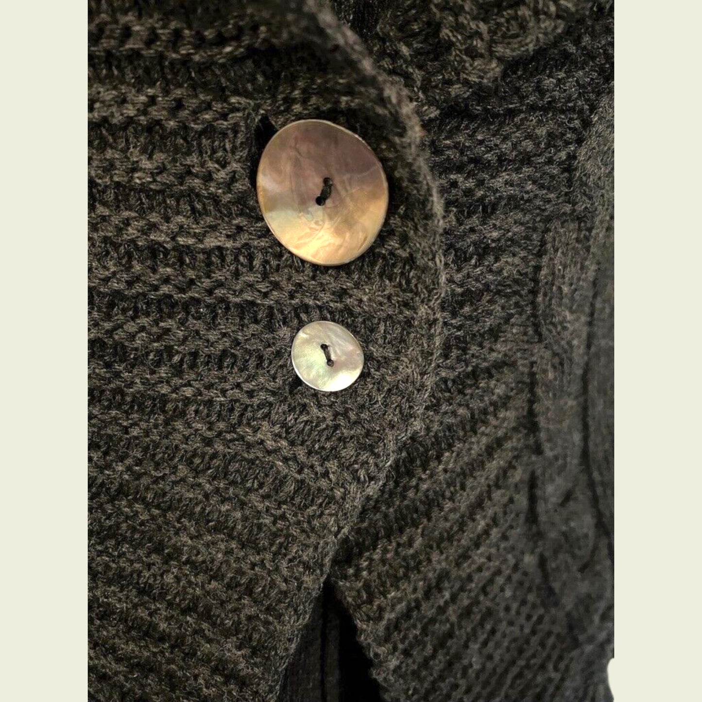 Close-up of a textured fabric with two buttons on a beige background