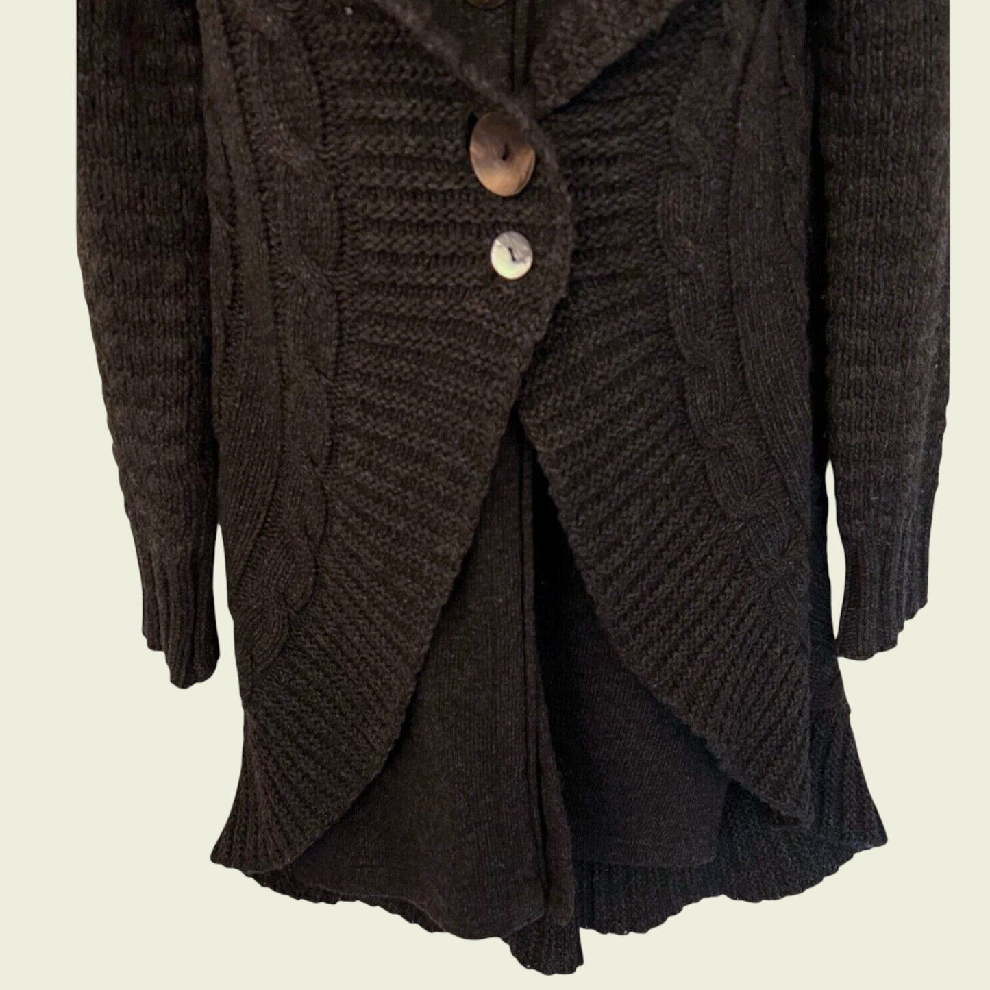 Dark brown knitted cardigan with buttons on a beige background
