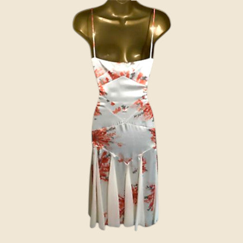 White dress with red floral pattern on a mannequin against a beige background