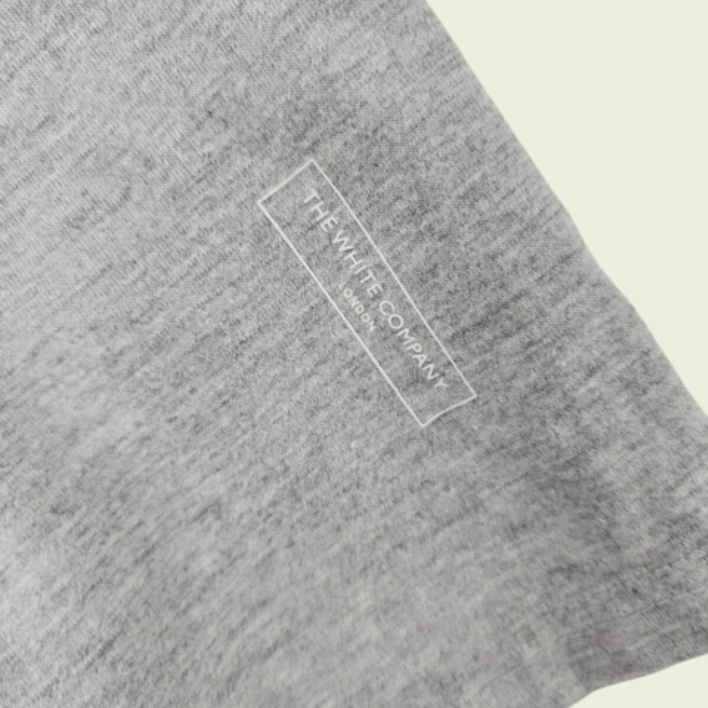 Gray fabric with 'The White Company' logo on a beige background