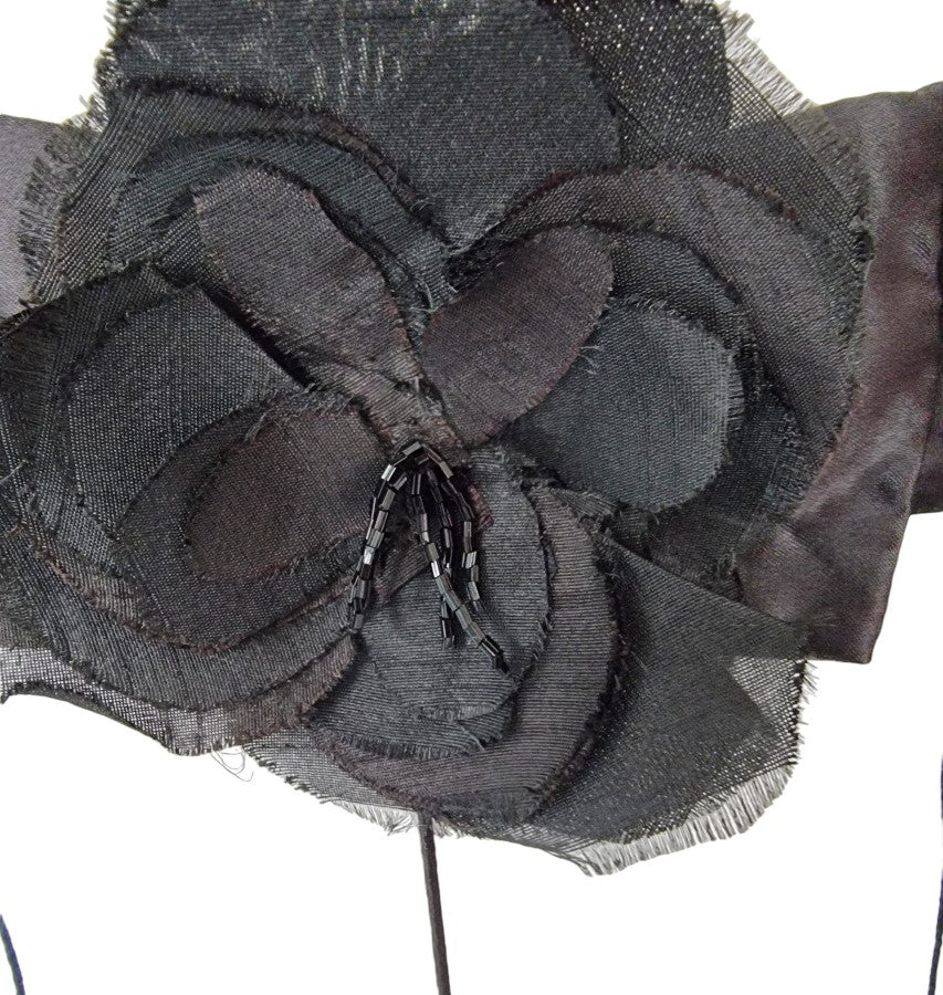 Close-up of a black fabric flower with a white background