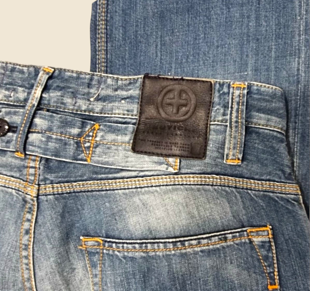 Close-up of a blue denim jeans back pocket with a brand label.