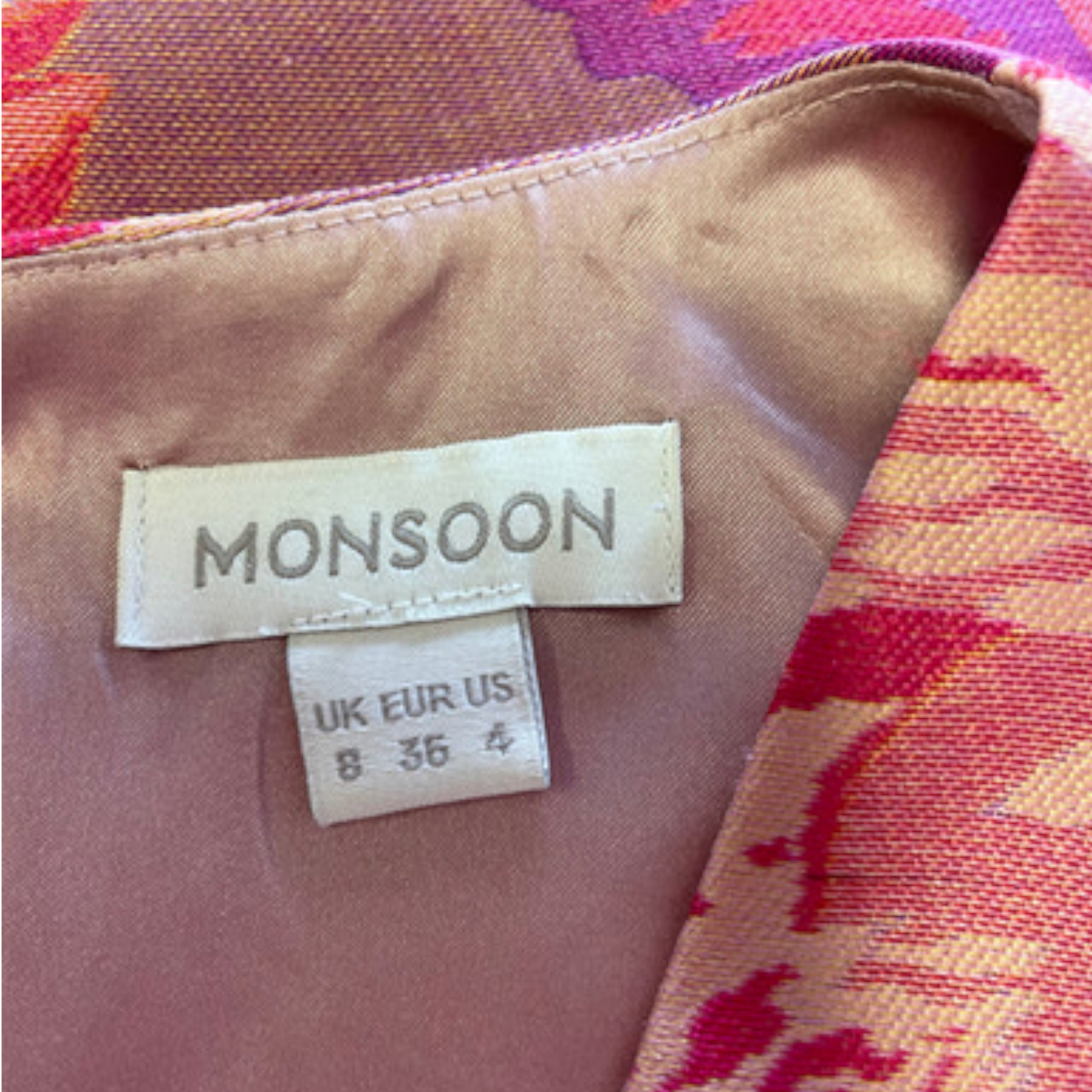 Close-up of a Monsoon label on fabric with a colorful background