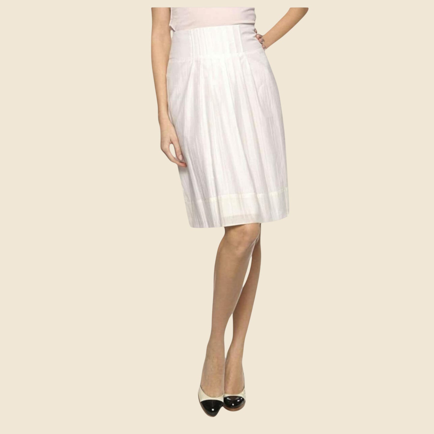 Cream pleated skirt worn by a person on a beige background