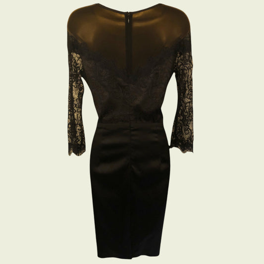 Black dress with sheer lace sleeves on a beige background