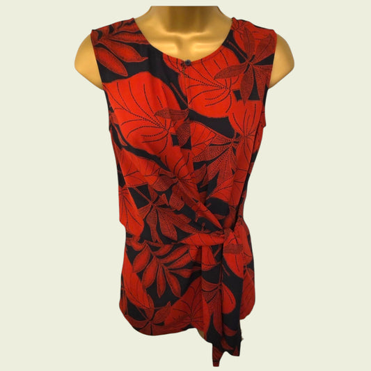 Red and black leaf-patterned top on a mannequin against a white background