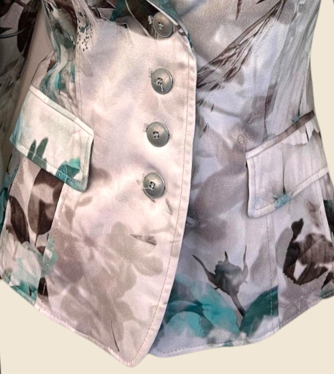 Close-up of a floral-patterned jacket with button details on a beige background