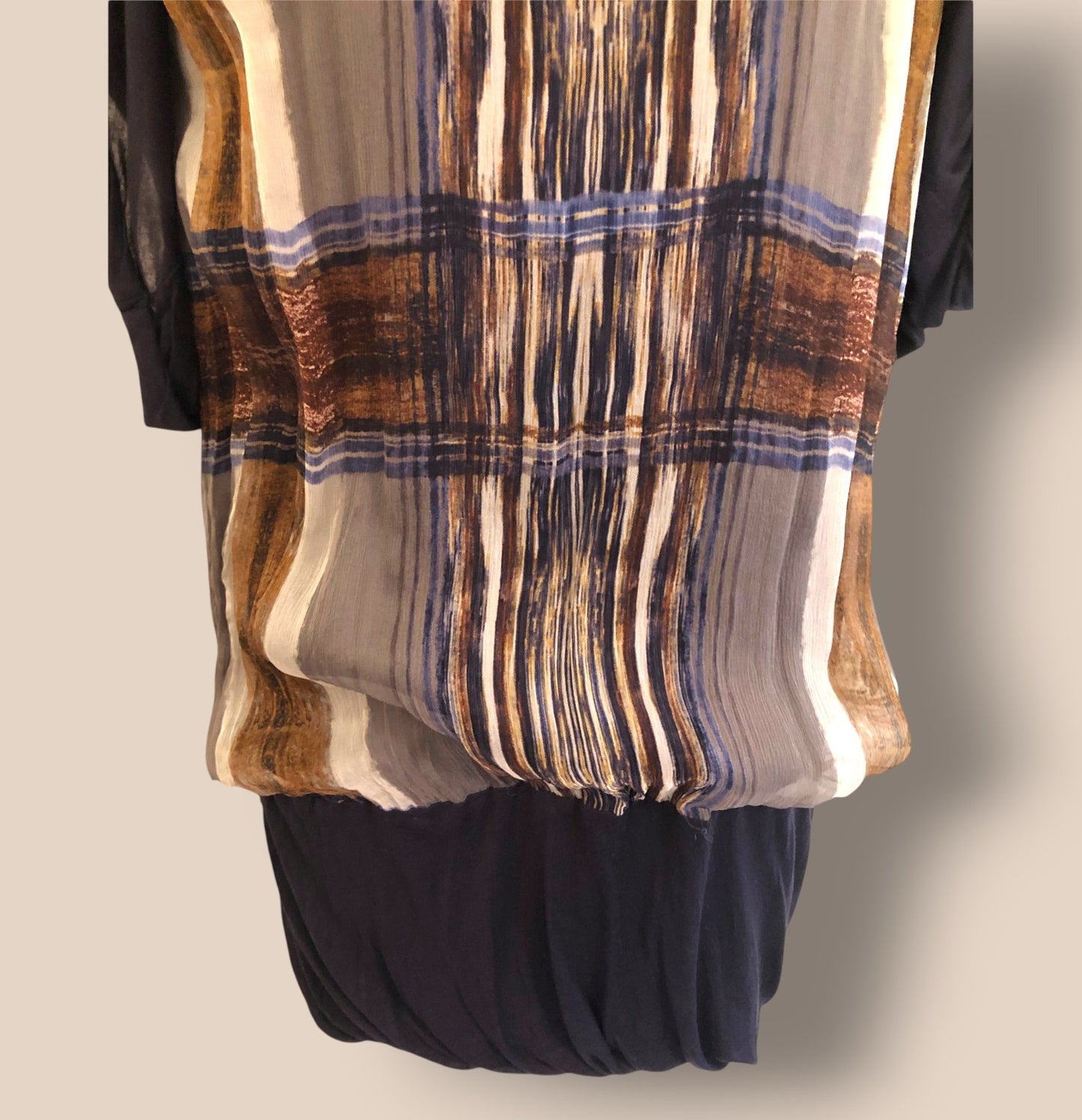 Plaid scarf draped over a black garment on a neutral background