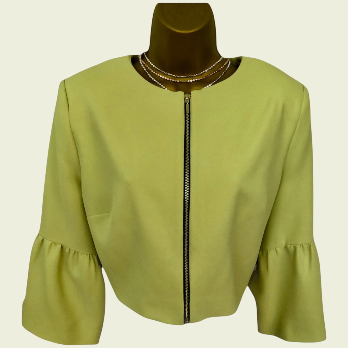 Green jacket with a zipper on a mannequin against a beige background