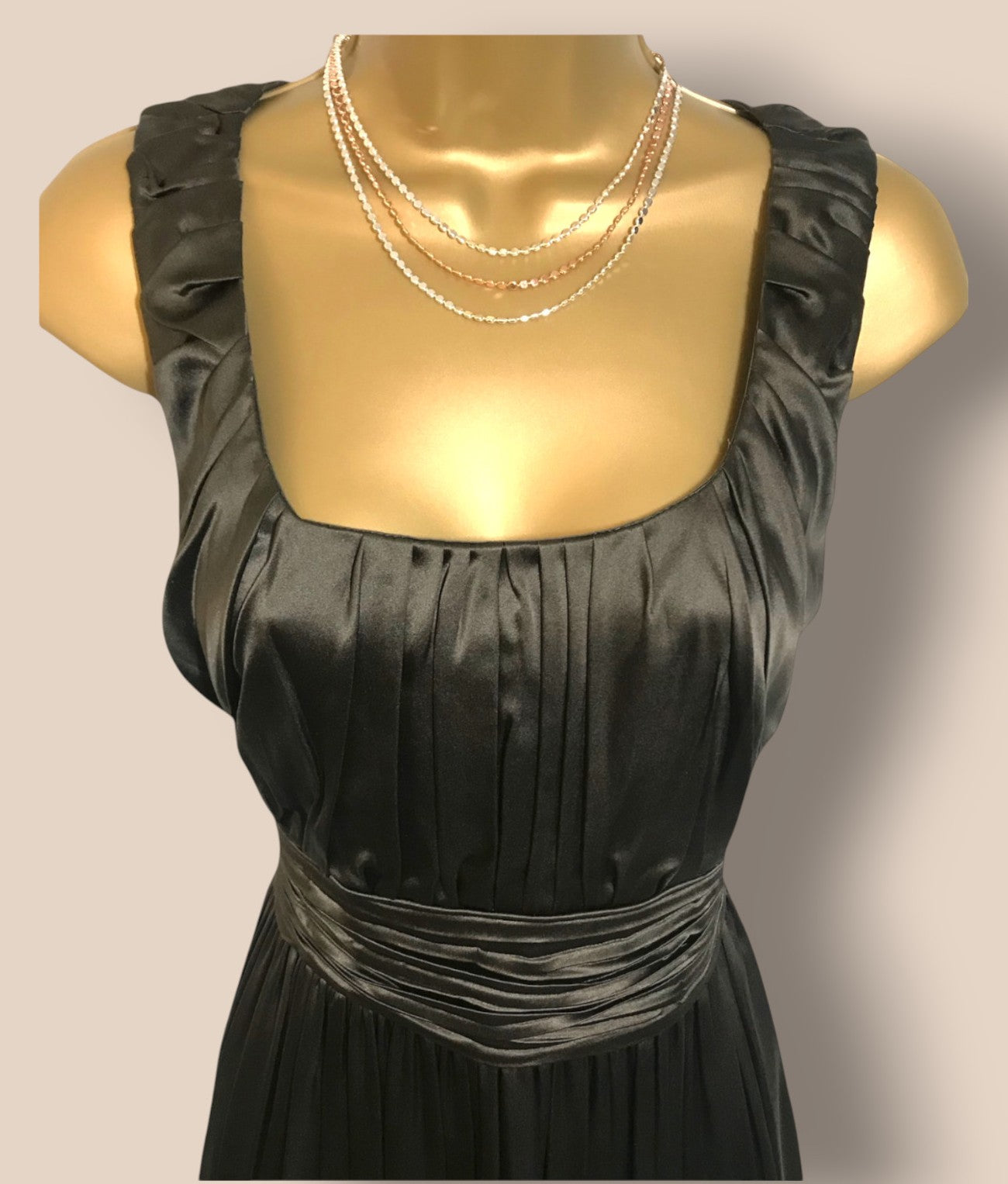 Black dress on a mannequin with a plain background