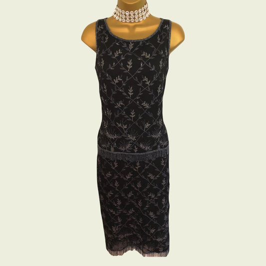 Black patterned dress on a mannequin with a white background