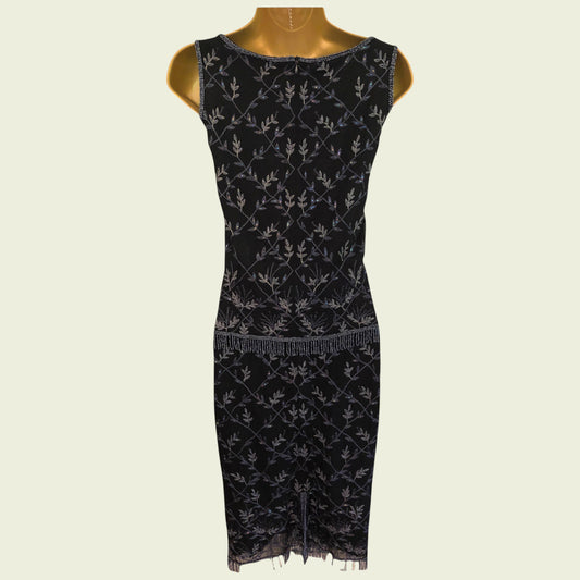 Black dress with silver floral pattern on a mannequin against a beige background