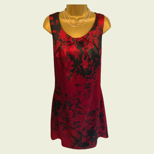 Red and black floral dress on a mannequin against a beige background