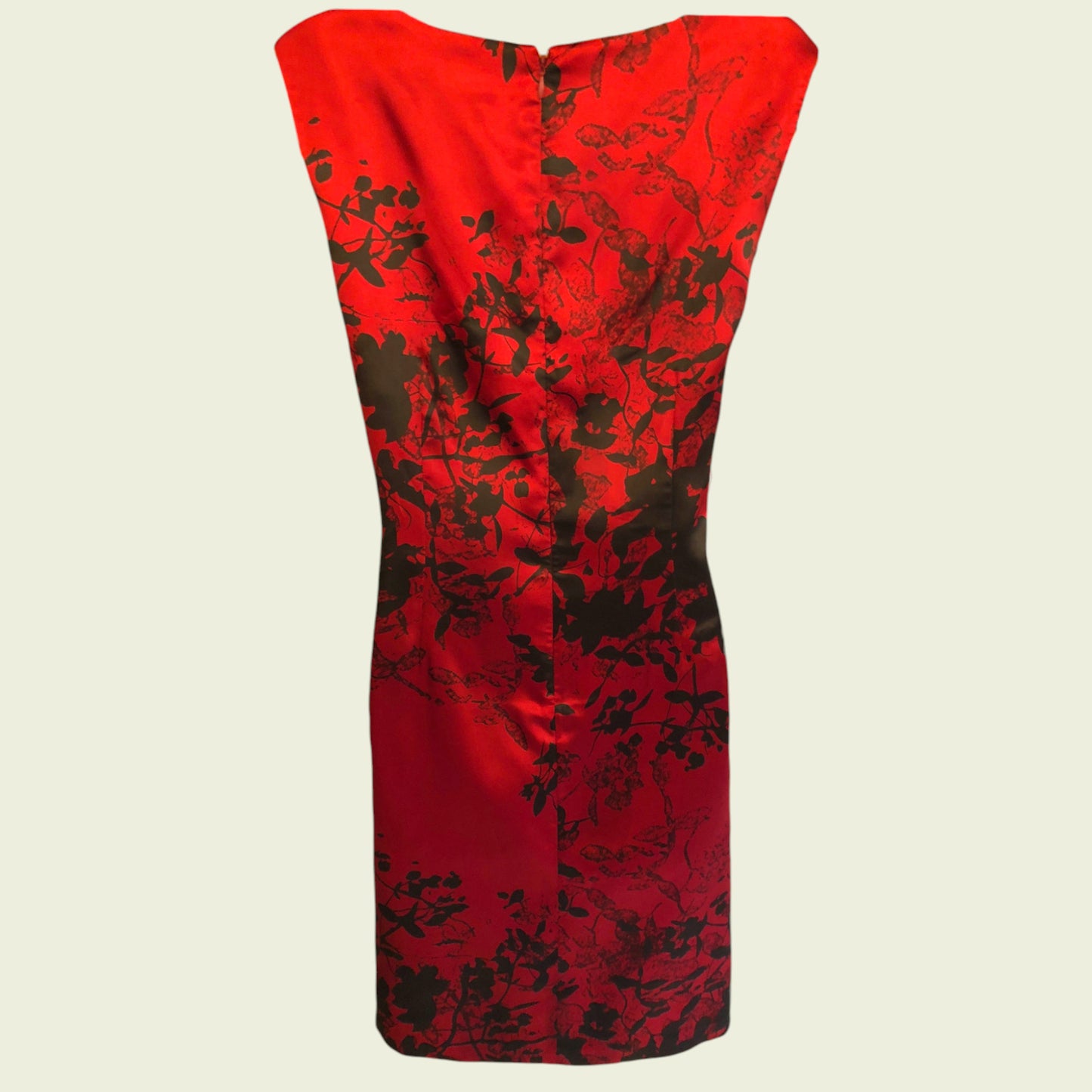Red dress with black floral pattern on a beige background