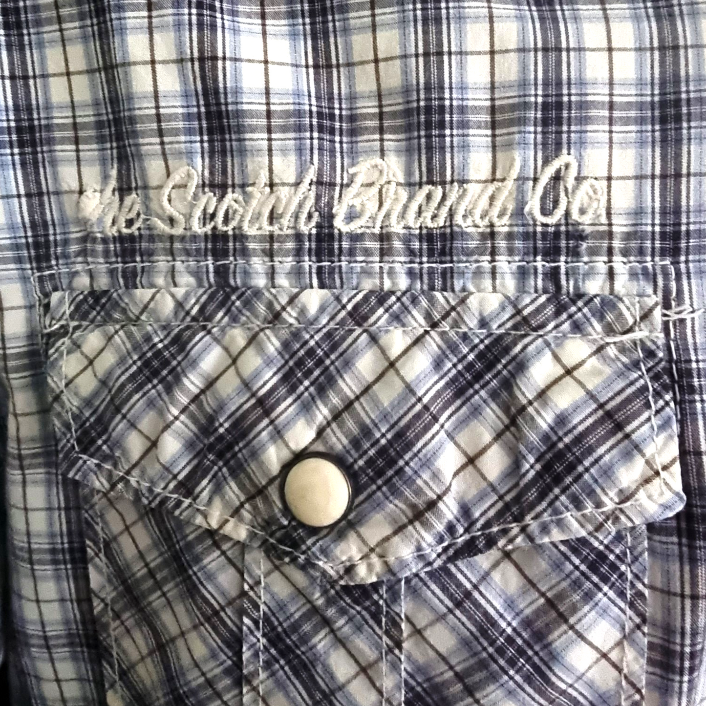 Plaid shirt with 'The Scotch Brand Co.' logo on a button