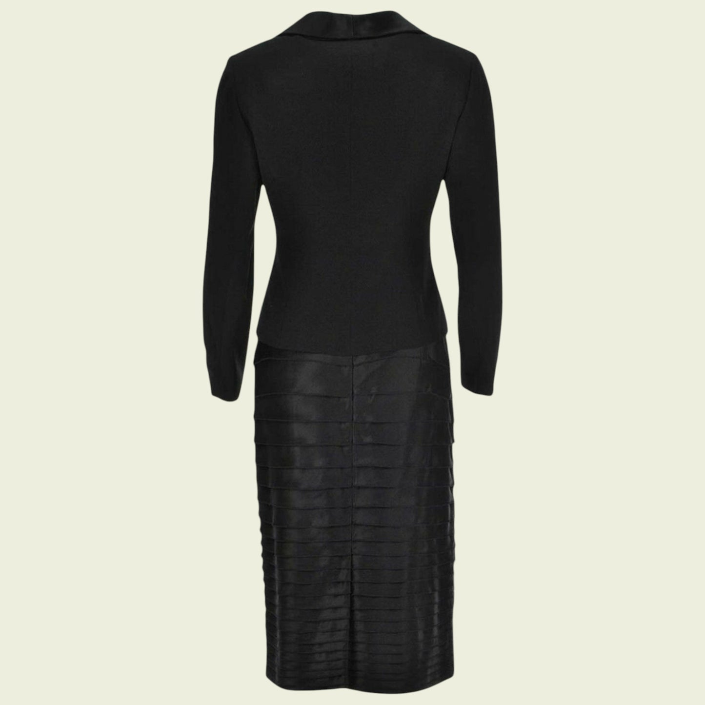 Black suit with long sleeves and a textured skirt on a beige background