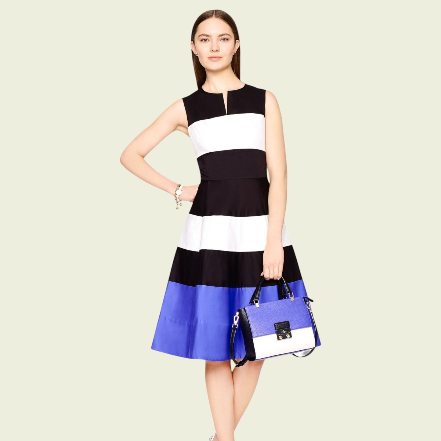 Woman wearing a black, white, and blue dress holding a matching handbag on a beige background